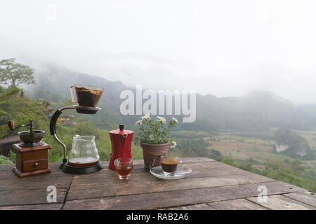 Tasse de café du matin avec le Rotary rectifieuse de café sur la table en bois avec vue sur la mer de brouillard, à Phu Langka Forest Park dans le district de Chiang Kham et Pong Dist Banque D'Images