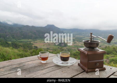 Tasse de café du matin avec le Rotary rectifieuse de café sur la table en bois avec vue sur la mer de brouillard, à Phu Langka Forest Park dans le district de Chiang Kham et Pong Dist Banque D'Images