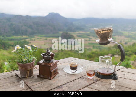 Tasse de café du matin avec le Rotary rectifieuse de café sur la table en bois avec vue sur la mer de brouillard, à Phu Langka Forest Park dans le district de Chiang Kham et Pong Dist Banque D'Images