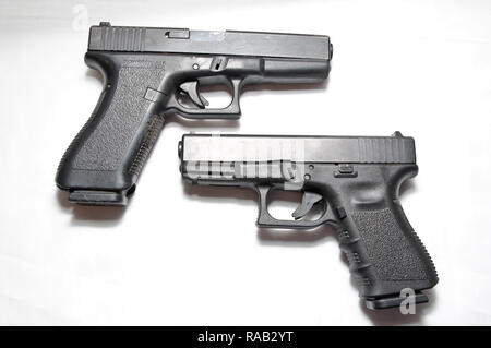 Deux pistolets semi-automatique noir, un 9mm et un calibre 40 sur un fond blanc montrant les différentes tailles d'eux Banque D'Images