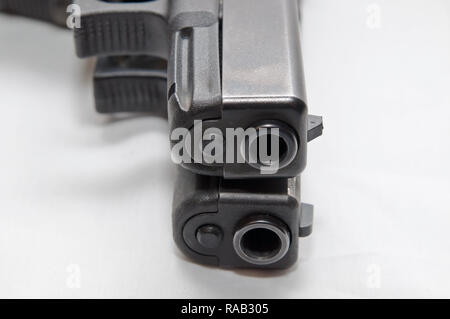 Deux pistolets semi-automatique noir, un 9mm et un calibre 40 avec l'une sur l'autre sur un fond blanc Banque D'Images