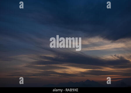 Fond de ciel coucher de soleil charmant calme avec des nuages blancs et la lumière du soleil du soir. Une nature magnifique arrière-plan. Photographie couleur horizontal. Banque D'Images