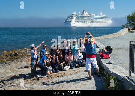 Les touristes asiatiques de prendre une photo de groupe avec un bateau de croisière dans l'arrière-plan, Bar Harbor, Maine, USA. Banque D'Images