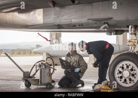 U.S. Air Force aviateur Senior Dyllan Jones et d'un membre de la 1re classe Wesley Johnson, 67e Unité de maintenance d'aéronefs F-15 Eagle chefs d'équipage, vérifier leurs ordres techniques lors de travaux d'entretien d'un F-15 Eagle Jan 10 2017, à Kadena Air Base, au Japon. Commandes aide technique de la maintenance des aéronefs suivre les procédures correctes pour diagnostiquer et réparer les problèmes qui peuvent survenir avec des aéronefs. Banque D'Images