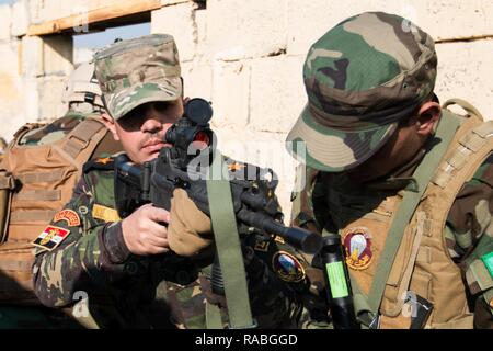 Le Lieutenant de l'armée iraquienne Hager Haider, instructeur des Rangers de l'Iraq, les entraîneurs un Irakien Ranger stagiaire 23 Janvier, Camp Taji, Iraq. Cette formation fait partie de la Force opérationnelle interarmées combinée globale - Fonctionnement résoudre inhérent, renforcer les capacités des partenaires pour accroître l'efficacité de la mission de combat des forces iraquiennes ISIL. Banque D'Images