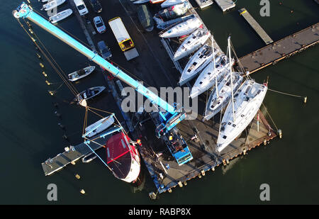 03 janvier 2019, Mecklembourg-Poméranie-Occidentale, Lannilis : le poisson vendu 'Coupe' Kehrwieder est levé avec une grue dans le port de Lannilis. La faucheuse a coulé en partie après la tempête et le poser sur le sol. (Photographie aérienne avec drone) Photo : Stefan Sauer/dpa-Zentralbild/dpa Banque D'Images