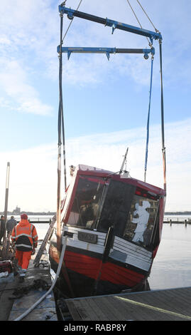 03 janvier 2019, Mecklembourg-Poméranie-Occidentale, Lannilis : le poisson vendu 'Coupe' Kehrwieder est levé avec une grue dans le port de Lannilis. La faucheuse a coulé en partie après la tempête et le poser sur le sol. Photo : Stefan Sauer/dpa-Zentralbild/dpa Banque D'Images