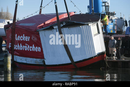 03 janvier 2019, Mecklembourg-Poméranie-Occidentale, Lannilis : le poisson vendu 'Coupe' Kehrwieder est levé avec une grue dans le port de Lannilis. La faucheuse a coulé en partie après la tempête et le poser sur le sol. Photo : Stefan Sauer/dpa-Zentralbild/dpa Banque D'Images