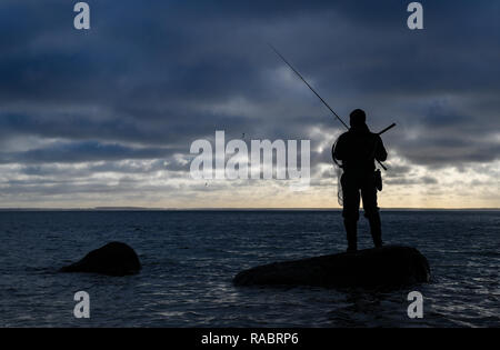 Vitt, Allemagne. Dec 30, 2018. Un pêcheur se distingue avec une canne sur une pierre dans la mer Baltique, près du village de pêcheurs de Vitt au Cap Arkona. Crédit : Patrick Pleul/dpa-Zentralbild/ZB/dpa/Alamy Live News Banque D'Images