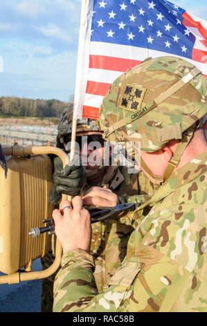 La frontière allemande et la Pologne - Des soldats du 3e Brigade Combat Team, 4e Division d'infanterie, basé à Fort Carson, Colorado, monter un drapeau américain devant un drapeau à la cérémonie d'échange allemand et frontière polonaise, le 12 janvier 2017. Ce déploiement est le début des rotations de brigades blindées en Europe dans le cadre de détermination de l'Atlantique. Les véhicules et équipements, pour un total de plus de 2 700 pièces, seront expédiés à la Pologne pour la certification avant de déployer à travers l'Europe pour la formation avec les nations partenaires. Cette rotation améliore les capacités de dissuasion, augmente la capacité de répondre aux pote Banque D'Images