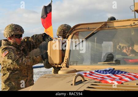 1er Sgt. Ernest Ramirez, sous-officier responsable de HHC, 1er Bataillon, 8e, 3e Armored Brigade Combat Team, 4ème infanterie allemande et américaine Divisionplaces les drapeaux sur une Humvee pour montrer la relation cohérente entre les deux alliés avant de traverser en Pologne de l'Allemagne, le 12 janvier, pour leur déploiement de neuf mois aux côtés de formation partenaires multinationaux. L'arrivée de 3-4 ABCT marque le début des rotations de brigades blindées en Europe dans le cadre de détermination de l'Atlantique. Cette rotation permettra d'améliorer les capacités de dissuasion dans la région, améliorer la capacité des États-Unis à r Banque D'Images