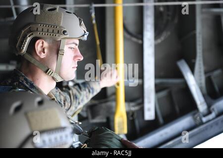 Une aire marine avec le 3e Bataillon de Reconnaissance, 3e Division de marines, III Marine Expeditionary Force, attend sur le bord de l'open C-130 Hercules de la porte pour le signal pour sauter lors d'un parachutage en ligne statique le 11 janvier 2017, à Yokota Air Base, le Japon. Le 36e Escadron de transport aérien Transport aérien fourni prend en charge de l'US Marine Corp saut d'une semaine de formation. Banque D'Images