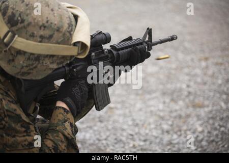 Le Capitaine Ian Carter-Condon une M16A4 carabine de service au cours de la table deux de sa qualification de tir annuel, 12 janvier 2017, au Camp Hansen, Okinawa, Japon. Le Marine Corps Tableau révisé deux du programme de tir de octobre 2016 d'augmenter l'adresse au tir et le réalisme de compétences dans un environnement de combat. Carter-Condon est un sous-officier des opérations du Régiment de logistique de combat avec-3, 3d, Groupe de la logistique maritime III Marine Expeditionary Force. Banque D'Images