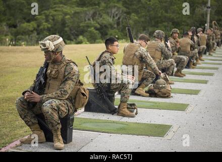 Marines de diverses unités au sein de l'Okinawa se préparent à leur tour de jouer la table deux partie de la qualification de tir annuel, le 12 janvier 2017, au Camp Hansen, Okinawa, Japon. Le Marine Corps Tableau révisé deux du programme de tir de octobre 2016 d'augmenter l'adresse au tir et le réalisme de compétences dans un environnement de combat. Le Corps exige que les Marines de la plage admissible à chaque année pour déterminer leur compétence au tir. Banque D'Images