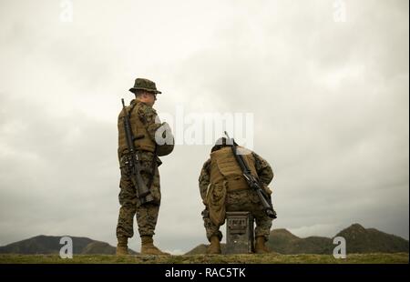 Marines attendent leur tour de tirer la table deux partie de leur qualification de tir annuel, 12 janvier 2017, au Camp Hansen, Okinawa, Japon. Le Marine Corps Tableau révisé deux du programme de tir de octobre 2016 d'augmenter l'adresse au tir et le réalisme de compétences dans un environnement de combat. Le Corps exige que les Marines de la plage admissible à chaque année pour déterminer leur compétence au tir. Banque D'Images