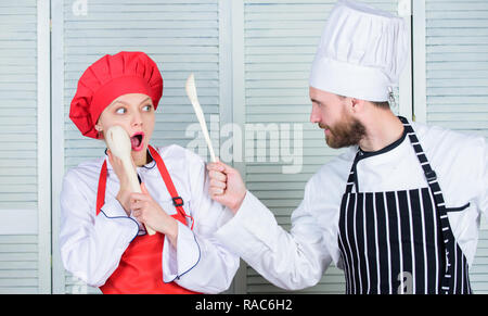 Règles de cuisine. Bataille culinaire concept. Femme et homme barbu show culinaire concurrents. Qui mieux cuisiner. Cuisine ultime défi. Bataille de deux chefs culinaires. La concurrence dans quelques arts culinaires. Banque D'Images