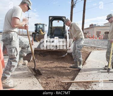 Le s.. John Hoyt et Senior Airman Jordanie Lechner, trottoir et l'équipement des artisans, affecté à la 49e Escadron de génie civil, d'une pelle de sol dans un chargeur à la base aérienne de Holloman, N.M., le 17 janvier 2017. Afin que l'asphalte pour être placés sur la surface, le sol sous elle doit être aussi lisse que possible. Un utilitaire rupture se produisit sous la route à l'origine de la 49e SCÉ de répondre rapidement et de résoudre le problème. Banque D'Images