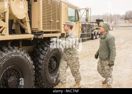 La CPS de l'armée américaine. Cody Kemper et Osiris Nick, 220e compagnie du génie, effectuer les contrôles sur les raccords et conduites d'air sur leurs camions pour s'assurer que la glace n'a pas affecté l'état de préparation de l'équipement dans Festus, Mo., 14 janvier 2017. Ce Citizen-Soldiers peut utiliser ces véhicules pour dégager les routes des arbres tombés et d'autres débris. La Garde nationale du Missouri est activé pour aider les organismes d'intervention d'urgence et sont prêts à appuyer les organismes de secours tout au long du Missouri avec les zones touchées, notamment les missions de l'aide de l'automobiliste en détresse, d'urgence et l'accès à l'habilitation de l'itinéraire des refuges d'urgence. Banque D'Images