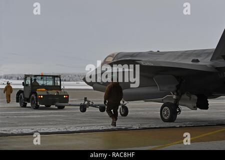 Marines affectés à l'Escadron de chasse marine attaque (VMFA) 121, 3rd Marine Aircraft Wing, déplacer F-35b dans un hangar, le 13 janvier 2017, lors d'un arrêt sur une base commune Elmendorf-Richardson, Alaska, en route vers Iwakuni Marine Corps Air Station, au Japon. VMFA-121 est le premier escadron opérationnel F-35B dans le Corps des Marines, avec son déménagement à 1ère aile d'avion à Iwakuni Marine. Le F-35B a été développé pour remplacer le Corps des Marines F/A-18 Hornet AV-8B Harrier, et EA- 6B Prowler. La version à décollage court atterrissage vertical (STOVL) est un véritable multiplicateur de force. La combinaison unique de furtivité et d'avant-garde Banque D'Images