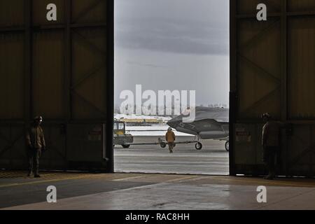 Marines affectés à l'Escadron de chasse marine attaque (VMFA) 121, 3rd Marine Aircraft Wing, déplacer F-35b dans un hangar, le 13 janvier 2017, lors d'un arrêt sur une base commune Elmendorf-Richardson, Alaska, en route vers Iwakuni Marine Corps Air Station, au Japon. VMFA-121 est le premier escadron opérationnel F-35B dans le Corps des Marines, avec son déménagement à 1ère aile d'avion à Iwakuni Marine. Le F-35B a été développé pour remplacer le Corps des Marines F/A-18 Hornet AV-8B Harrier, et EA- 6B Prowler. La version à décollage court atterrissage vertical (STOVL) est un véritable multiplicateur de force. La combinaison unique de furtivité et d'avant-garde Banque D'Images