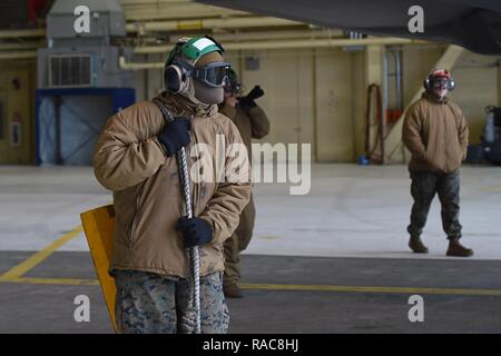 Marines affectés à l'Escadron de chasse marine attaque (VMFA) 121, 3rd Marine Aircraft Wing, déplacer F-35b dans un hangar, le 13 janvier 2017, lors d'un arrêt sur une base commune Elmendorf-Richardson, Alaska, en route vers Iwakuni Marine Corps Air Station, au Japon. VMFA-121 est le premier escadron opérationnel F-35B dans le Corps des Marines, avec son déménagement à 1ère aile d'avion à Iwakuni Marine. Le F-35B a été développé pour remplacer le Corps des Marines F/A-18 Hornet AV-8B Harrier, et EA- 6B Prowler. La version à décollage court atterrissage vertical (STOVL) est un véritable multiplicateur de force. La combinaison unique de furtivité et d'avant-garde Banque D'Images