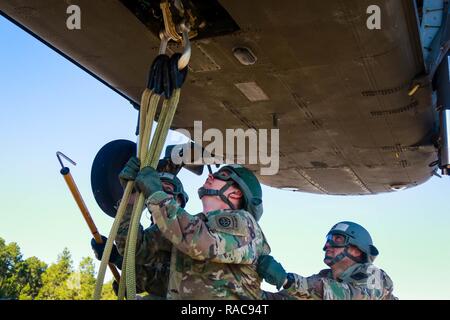 Les soldats de l'École d'assaut aérien DeGlopper, XVIII Airborne Corps, assurer la connexion d'une élingue fixée au ventre d'un UH-60 Black Hawk affecté à la 2ème bataillon d'hélicoptères d'assaut, 82e Brigade d'aviation de combat à Fort Bragg, N.C., Jan 19. Banque D'Images