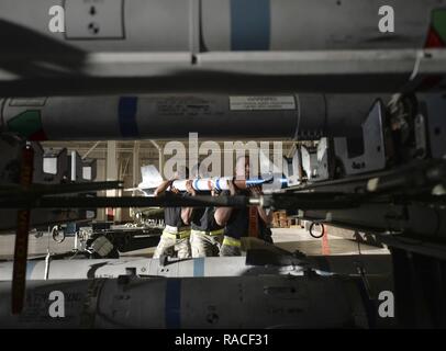 Le sergent de l'US Air Force. Christopher A. Holmes, Senior Airman Michael B. joue et d'un membre de la 1re classe Elie Cruz, 43e Unité de maintenance d'Aéronefs Systèmes d'armement des avions formation techniciens supprimer un missile à partir d'une plate-forme tenue pour charger manuellement dans un F-22 Raptor à la base aérienne Tyndall, en Floride, le 20 janvier 2017. L'équipe de chargement a été le premier de quatre équipes de concourir pour l'équipe de chargement 2016 de l'année. Banque D'Images