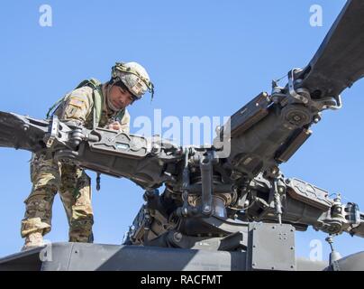 Le sergent de l'armée américaine. Alvin Atalig un inspecteur technique avec Delta Co., 1er Bataillon de Reconnaissance, d'attaque, 25e Brigade d'aviation de combat confirme de numéros de série sur un AH-64 Apache à Fort Irwin, en Californie, le 24 janvier 2017. C'est 1-25ème ARB's première rotation au Centre National d'entraînement. Cnt fournit des unités et du personnel militaire des États-Unis avec des scénarios de formation de pré-déploiement dans tous les aspects des conflits armés. Banque D'Images