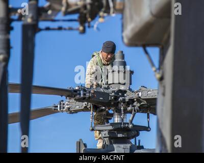 Le sergent de l'armée américaine. Alvin Atalig un inspecteur technique avec Delta Co., 1er Bataillon de Reconnaissance, d'attaque, 25e Brigade d'aviation de combat confirme de numéros de série sur un AH-64 Apache à Fort Irwin, en Californie, le 24 janvier 2017. C'est 1-25ème ARB's première rotation au Centre National d'entraînement. Cnt fournit des unités et du personnel militaire des États-Unis avec des scénarios de formation de pré-déploiement dans tous les aspects des conflits armés. Banque D'Images