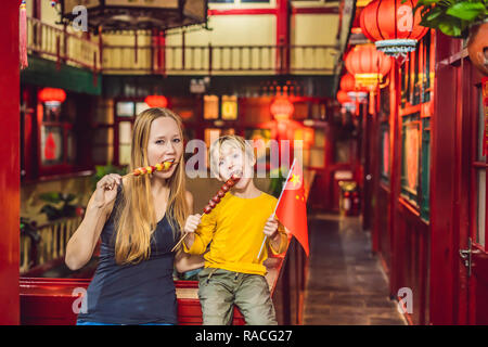 Profiter de vacances en Chine. Heureux touristes maman et son fils avec un drapeau chinois et chinois traditionnel avec des fruits confits sur un arrière-plan chinois. Voyage en Chine avec les enfants la notion. Visa de transit de 72 heures, 144 heures en Chine BANNER, format long Banque D'Images