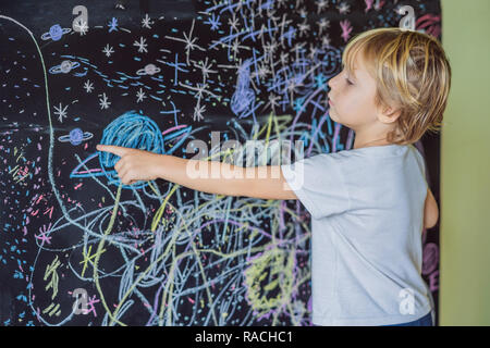 Petit garçon vers l'espace, les planètes et les étoiles sur le mur Banque D'Images