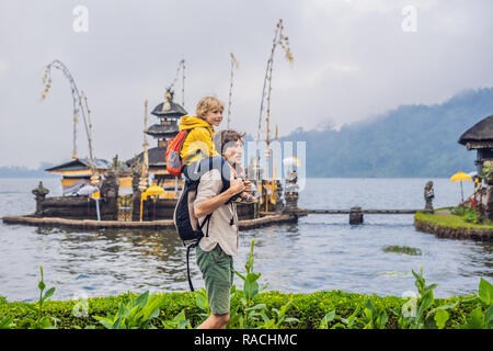 Père et fils dans l'arrière-plan de Pura Ulun Danu Bratan, Bali. Hindu Temple entouré de fleurs sur le lac Bratan, Bali. Grand temple de l'eau Shivaite à Bali, Indonésie. Temple hindou. Voyager avec des enfants concept Banque D'Images