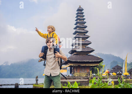 Père et fils dans l'arrière-plan de Pura Ulun Danu Bratan, Bali. Hindu Temple entouré de fleurs sur le lac Bratan, Bali. Grand temple de l'eau Shivaite à Bali, Indonésie. Temple hindou. Voyager avec des enfants concept Banque D'Images