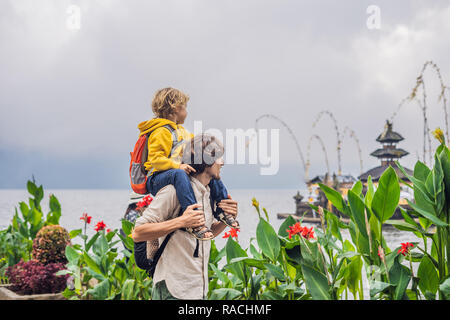 Père et fils dans l'arrière-plan de Pura Ulun Danu Bratan, Bali. Hindu Temple entouré de fleurs sur le lac Bratan, Bali. Grand temple de l'eau Shivaite à Bali, Indonésie. Temple hindou. Voyager avec des enfants concept Banque D'Images