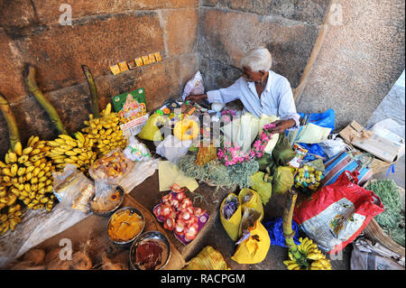 L'homme préparer les offres de puja, fleurs, fruits et noix au 11ème siècle temple de Brihadisvara, Thanjavur, Tamil Nadu, Inde, Asie Banque D'Images