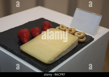 Tranche de fromage de brebis sur nappe noire décorée de Taralli et fraises. Italien Banque D'Images