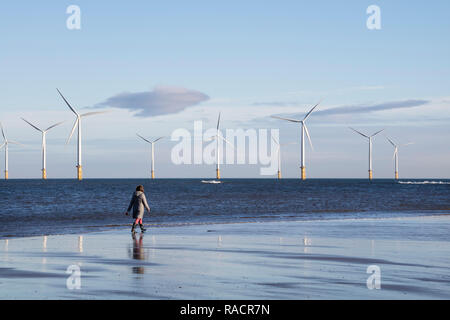 Personne marchant passé Partie de la turbine 27 62MW d'éoliennes près de Teesside Redcar, North Yorkshire, UK Banque D'Images