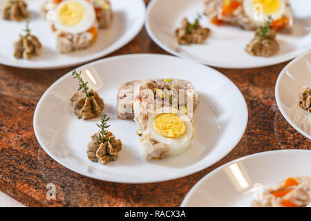 Gelée de viande avec des légumes et des oeufs on white plate Banque D'Images