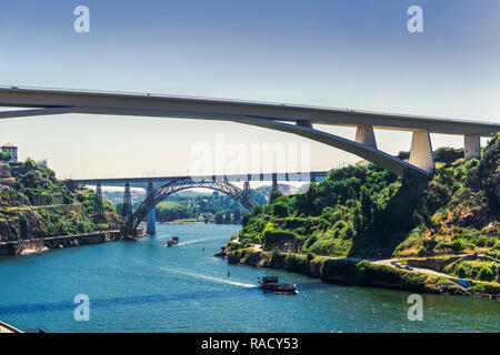 Avis de trois ponts sur la rivière Douro avec des navires de tourisme en face de l'Infante D. Henrique, Maria Pia et St John ponts, Porto, Portugal, Europe Banque D'Images