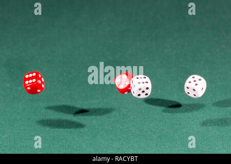 Quatre dés rouge et blanc qui tombe sur un tableau vert Banque D'Images