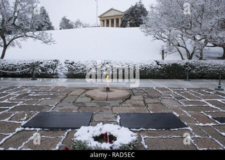 Des couvertures de neige la zone entourant le président John F. Kennedy's tombe dans le Cimetière National d'Arlington, le 30 janvier 2017 à Arlington, Va., éclairé par Mme Kennedy lors de l'enterrement, la flamme éternelle brûle entre le centre d'un cinq-pied-plat circulaire en pierre de granit à la tête de la tombe. Banque D'Images