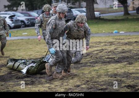 Les soldats de l'Armée américaine affecté à la 16e Brigade d'aviation de combat, 7e Division d'infanterie, déplacer une victime simulée pendant le combat gareautrain formation à Joint Base Lewis-McChord, dans l'État de Washington, le 26 janvier 2017. 16e CAB medecins a dirigé la formation, qui comprenait des opérations spéciales de l'Armée de l'air américaine de contrôle aérien tactique des spécialistes (ECAT) afin de préparer les participants à soigner les blessés au cours des opérations. Banque D'Images