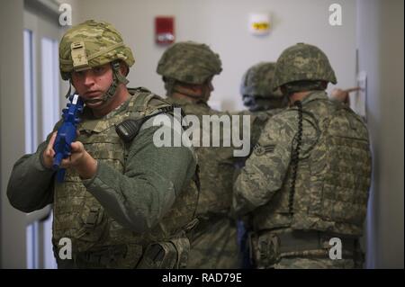 Ty Coleman, Senior Airman 88e Escadron des Forces de sécurité patrouilleur, fournit la couverture que le reste de son équipe consulte un diagramme du bâtiment au cours d'un exercice d'entraînement et de tir, le 30 janvier 2017, sur la base aérienne de Wright-Patterson, Ohio. Même si le "auteur" a été rapidement arrêté, humains nécessaires pour balayer le bâtiment pour s'assurer qu'il n'y avait plus de danger. Banque D'Images