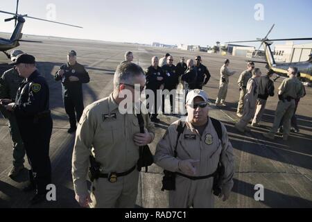 U.S. Customs and Border Protection, aérien et maritime, des opérations d'interdiction aérienne, Agent David Grantham, à gauche, et l'agent Daniel Flores parler sur la ligne de vol en tant que pilotes et l'équipage d'organismes d'application de la loi partenaires rencontrez à Ellington Field Joint Reserve Base à l'avance de Super Bowl LI in Houston, Texas, Jan 31, 2017. U.S. Customs and Border Protection Banque D'Images