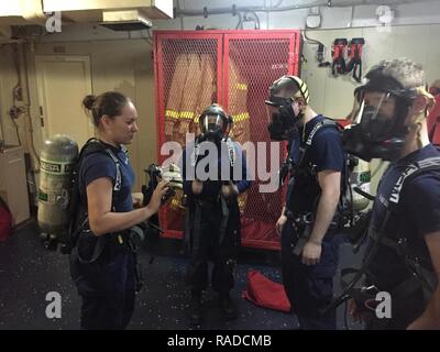 La Garde côtière des États-Unis, le Maître de 3e classe Courtney va (à gauche), un dommage controlman déployés à bord du garde-côte américain Polar Star, assure l'état de fonctionnement de l'équipement de sécurité à bord avec des membres de l'équipage du Polar Star, 12 janvier 2017. L'équipage de l'étoile Polaire effectue ce déploiement dans le cadre de l'opération annuelle d'offrir les fournitures nécessaires à la National Science Foundation des stations de recherche en Antarctique. Banque D'Images