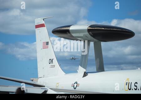 Un E-3 Sentry Airborne Warning and Control System en place d'avions taxis 25 janvier après le retour d'une mission à Joint Base Harbor-Hickam Pearl, Mississippi, tandis qu'un avion de passagers se prépare à terre dans l'arrière-plan. Des réservistes de la 513e Groupe de contrôle de l'air déployés dans les îles Hawaï afin d'assurer le commandement et le contrôle de Sentry Aloha 17-01, une réserve principalement et de la Garde nationale aérienne exercice qui implique plus de 40 avions et 1 000 militaires. Banque D'Images