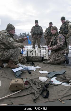 Un centre de formation de combat ukrainiens formateur médical rappelle à un étudiant d'utiliser des gants pendant le premier Ukrainien-led lutter contre Cours de premiers soins de la paix et de sécurité internationale, près de l'viv, l'Ukraine, le 1 février. Le cours de secourisme de combat enseigné des soldats de l'armée ukrainienne 1er Bataillon, 28e Brigade d'infanterie mécanisée de la manière de traiter les plaies de bataille, fournissant des connaissances pouvant sauver des vies. Banque D'Images