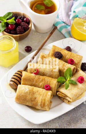 Petit-déjeuner de crêpes en bonne santé. Pile de crêpes fines crêpes faites maison ou farine de grains entiers, servi avec du miel et de baies fraîches. Banque D'Images