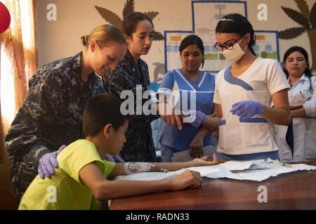 TRUJILLO, le Honduras (31 déc. 13, 2018) - Le Lieutenant Melissa Mathers (à gauche) et le lieutenant J.G. Karen Jimenez Gudino (centre- gauche), infirmières affectées au navire-hôpital USNS Comfort (T-AH 20), d'expliquer les procédures de nettoyage d'un cathéter central à insertion périphérique (PICC) ligne sur un jeune patient à des infirmières et infirmiers du Honduras lors d'un échange d'experts en la matière (SMEE). Le Smee a eu lieu entre la Marine et les officiers médecins honduriens dans un hôpital local. Le confort est de 11 semaines sur une mission d'appui médical à l'Amérique centrale et du Sud dans le cadre du U.S. Southern Command's Enduring promesse initiative. Wo Banque D'Images