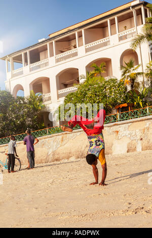 Stone Town, Zanzibar, Tanzanie - 7 janvier, 2017. Handsome man doing handstand on beach. Banque D'Images